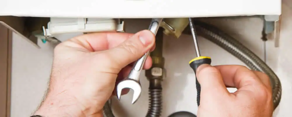 Boiler repair technician tightening pipe fittings and connections in Evansville, IN