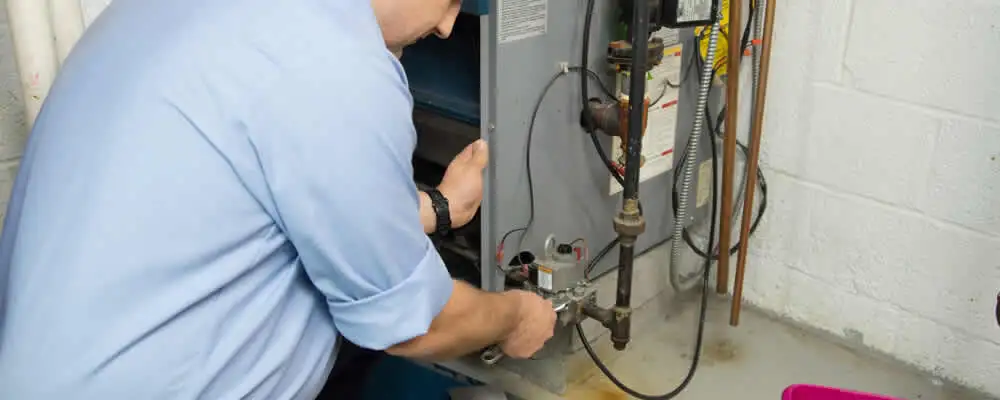 Furnace repair technician inspecting and servicing a home heating system in Evansville, IN