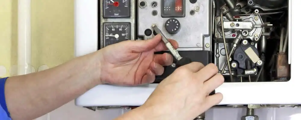 Heating repair technician adjusting boiler controls and components in Evansville, IN