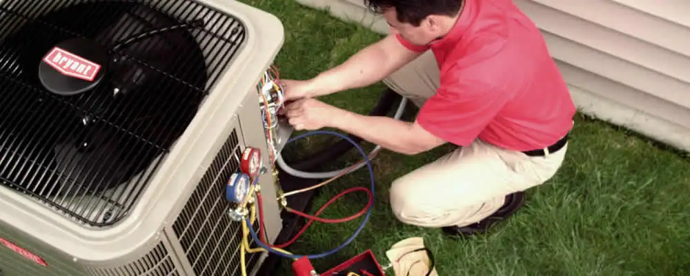 HVAC technician servicing an outdoor air conditioner unit in Evansville, IN