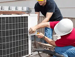HVAC technicians repairing an outdoor AC unit on a rooftop in Evansville, IN