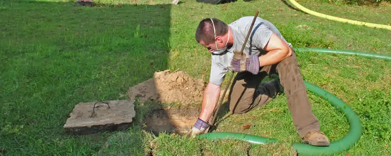 Septic pumping technician servicing a residential septic tank in Evansville, IN
