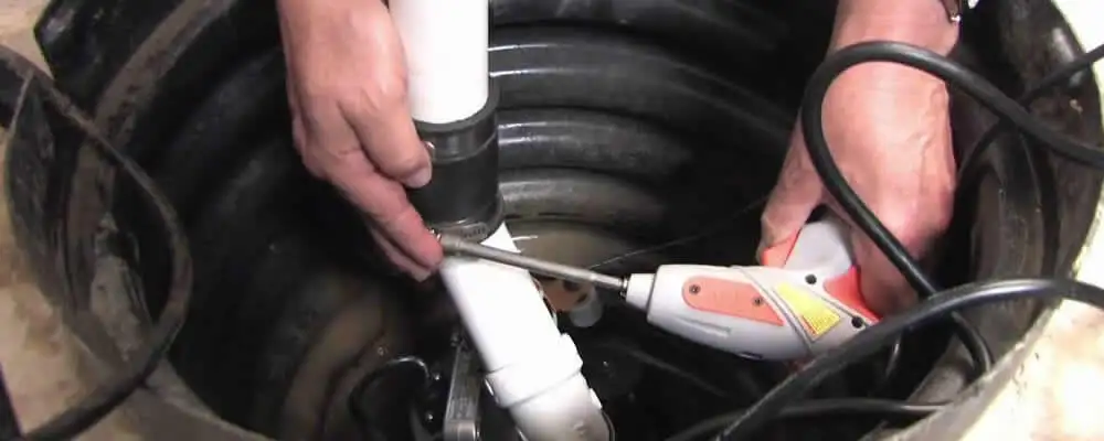 Sump pump installation technician connecting PVC discharge piping in Evansville, IN
