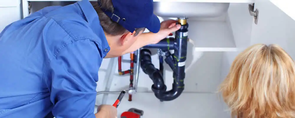 Plumber repairing under-sink drain pipes and fittings in Evansville, IN